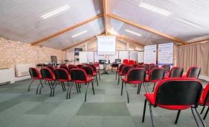 a conference room with red chairs in a room at Hotel Restaurant La Dame du Lac in Monflanquin