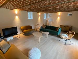 Quadratum 1769 في Herzele: غرفة معيشة مع أريكة وكراسي وتلفزيون