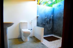 Prime Surfers Bungalow في آروغام باي: حمام مع دش مع مرحاض ومغسلة
