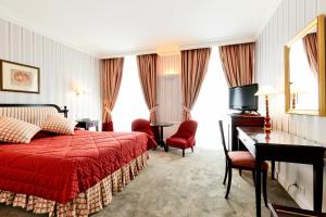 1 dormitorio con cama roja, escritorio y sillas en Golden Tulip Washington Opera, en París