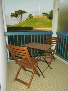 een houten tafel en stoelen op een balkon met een tafel bij Studio - Port du Croisic in Le Croisic