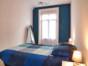 - une chambre bleue avec un lit et une fenêtre dans l'établissement Appartement hypercentre au 1er, ZOO - 24h du Mans, à La Flèche