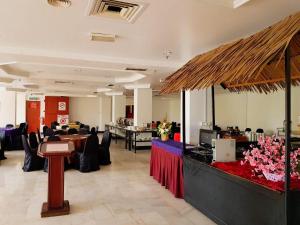 a lobby with a restaurant with tables and chairs at Hotel Grand Crystal in Alor Setar