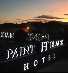 un panneau indiquant un parking avec le coucher du soleil en arrière-plan dans l'établissement Paint It Black Hotel & Spa, à Gevgelija