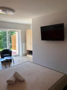 a living room with a flat screen tv on a wall at Pension Zum Stein in Hohenkirchen