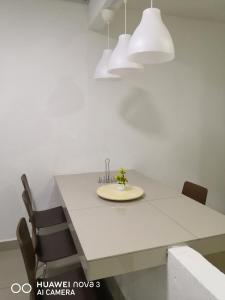 a dining room with a white table and chairs at Abah 2 Room Homestay in Pasir Gudang +5 photos