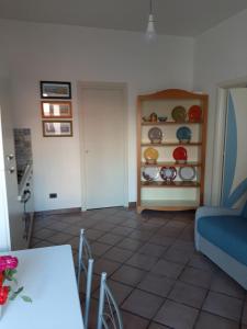 a living room with a table and a shelf of plates at Il Glicine - Casa vacanza in Procida