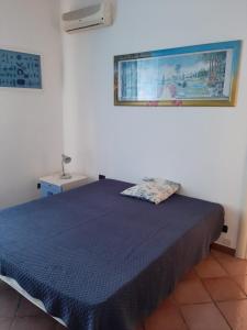 a bedroom with a bed with a blue bedspread at Il Glicine - Casa vacanza in Procida