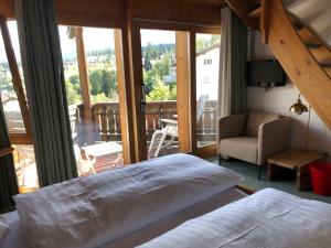 a bedroom with a bed and a view of a balcony at Arena Guesthouse in Flims