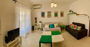 - un salon avec un canapé et une télévision dans l'établissement Apartamento Praia de Altura-Terraço BBQ-Wfi-AC, à Altura