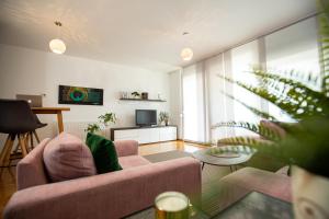 ein Wohnzimmer mit Sofa und Fernseher in der Unterkunft Bright 2-Bed Apartment Free Parking & WiFi - Walk to Old Town in Ljubljana
