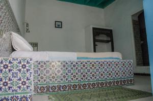 a bedroom with a bed with a quilt on it at Hôtel Djerba Erriadh in Houmt Souk +128 photos