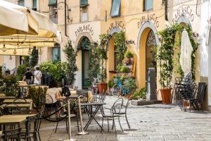 una caffetteria all'aperto con tavoli e sedie e un edificio di Giusy's Apartment a Lucca