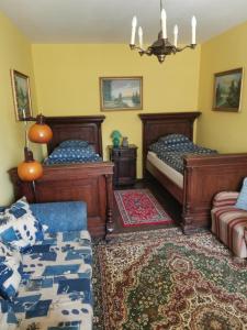 a bedroom with two beds and a couch at Mátrai Vadászház 2 in Mátraterenye