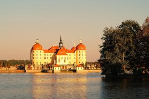 ein großes Gebäude mit orangefarbenen Kuppeln auf dem Wasser in der Unterkunft Ferienwohnung Sobrigau in Sobrigau