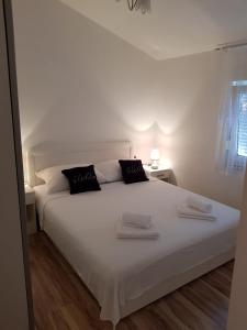 Una cama blanca con dos toallas encima. en Apartman Andrea en Zadar