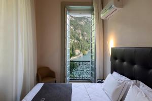 a bedroom with a bed and a window with a view at Hotel Villa Cipressi, by R Collection Hotels in Varenna