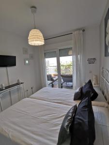 a bedroom with a large white bed with black pillows at Mi Capricho in Sitio de Calahonda
