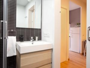 baño con lavabo blanco y azulejos negros en Sagrada Familia, en Barcelona