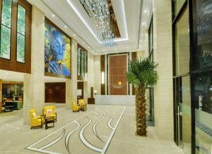 a lobby with a palm tree in the middle of a building at Lemon Tree Premier, Dwarka in Dwarka