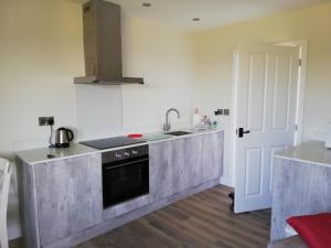 a kitchen with a sink and a stove at The Milk Barn in Ashbourne