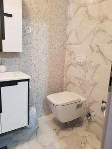a white bathroom with a toilet and a sink at Studio Apartment Lili in Zadar
