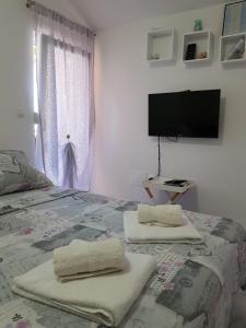 a bedroom with a bed with two towels on it at Studio Apartment Lili in Zadar