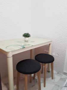 una mesa con dos taburetes y una planta en ella en Studio Apartment Lili en Zadar