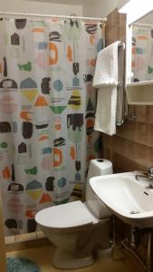 een badkamer met een toilet, een wastafel en een douchegordijn bij Entire private 2 rooms apartment in city center of Malmö close to Copenhagen in Malmö
