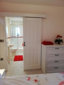 a bedroom with a door leading to a bathroom at The Milk Barn in Ashbourne