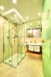 a bathroom with a glass shower and a sink at Hotel Garni Urezza in Ischgl