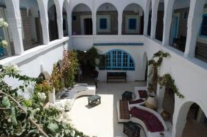 an indoor courtyard of a building with chairs and tables at Hôtel Djerba Erriadh in Houmt Souk
