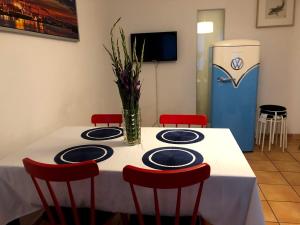 een tafel met stoelen en een vaas met bloemen erop bij Apartment in Sternschanze in Hamburg