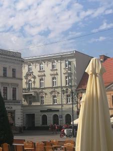 un paraguas blanco sentado frente a un edificio en Rynkowy, en Rybnik