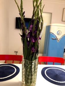 een vaas gevuld met paarse bloemen zittend op een tafel bij Apartment in Sternschanze in Hamburg