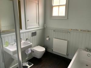 een badkamer met een wastafel, een toilet en een spiegel bij 7 Precentor's Court in York