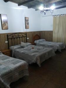 a room with three beds in a room at Hostal Breñaverde in Gaucín