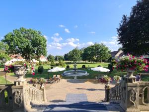 a garden with a fountain and tables and umbrellas at Pałac Henryków in Szprotawa