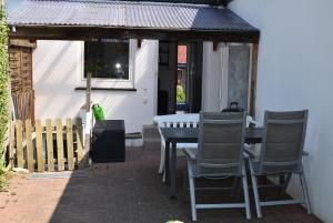 a table and chairs on a patio with a roof at Haus Pries in Kiel
