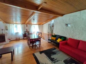 a living room with a red couch and a table at Casa do Rio in Coimbra