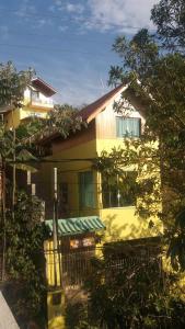 une maison jaune avec un auvent vert dessus dans l'établissement Alta Vista, à Penedo