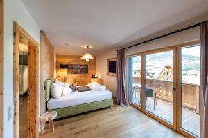 Łóżko lub łóżka w pokoju w obiekcie ALMGUT - Mountain Wellness Hotel