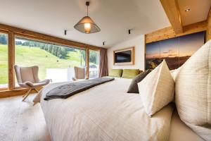Łóżko lub łóżka w pokoju w obiekcie ALMGUT - Mountain Wellness Hotel