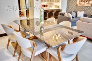 une salle à manger avec une table en bois et des chaises blanches dans l'établissement Al Majara by EMAAR, Dubai Marina, à Dubaï