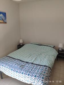 - un lit avec une couette bleue dans une chambre dans l'établissement Gîte Aische-en-Refail, à Aische-en-Refail