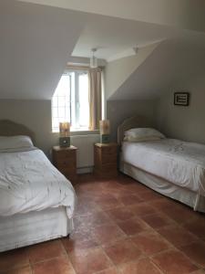 Hooe的住宿－Rosemary Cottage，阁楼卧室配有两张床,铺有瓷砖地板。