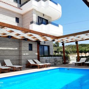 un patio con piscina y una casa en Hotel Sole, en Sarandë