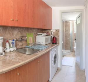 a kitchen with a sink and a washing machine at Emilios Stone House in Gaios