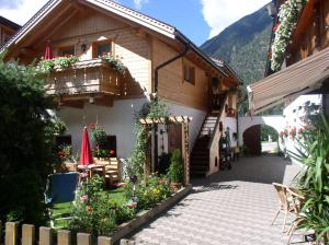 a house with a courtyard with flowers in front of it at Luggishof in Campo Tures