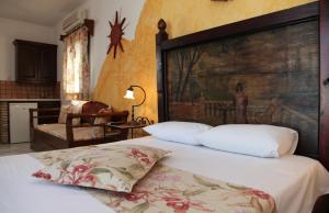 Schlafzimmer mit einem Bett mit einem großen Kopfteil aus Holz in der Unterkunft Villa Danai in Agia Anna